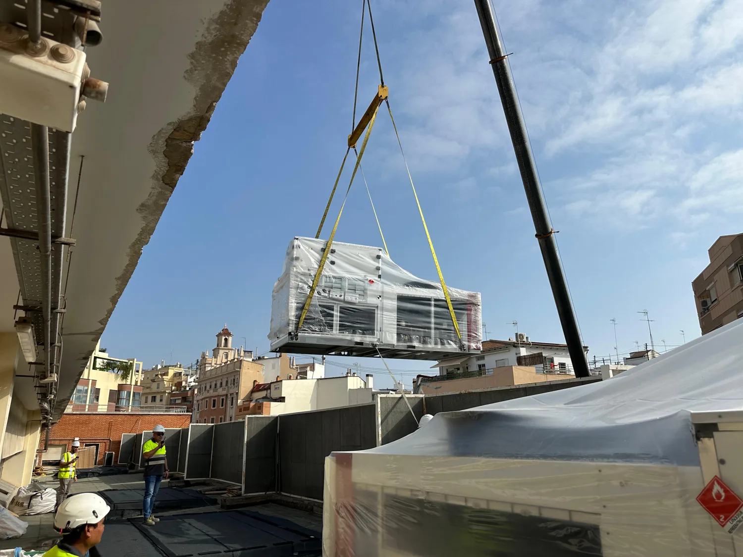 Obras — Grúa instalando equipos de aire acondicionado en la cubierta del Mercat de Russafa en Valencia